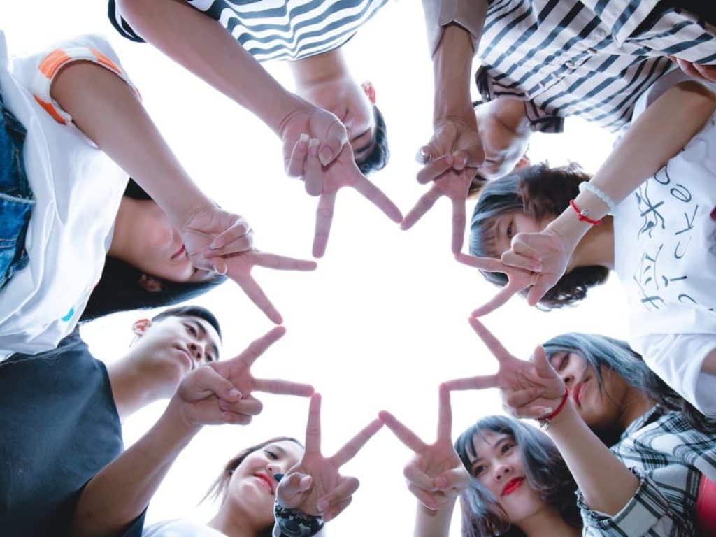 Group of people forming star with hand