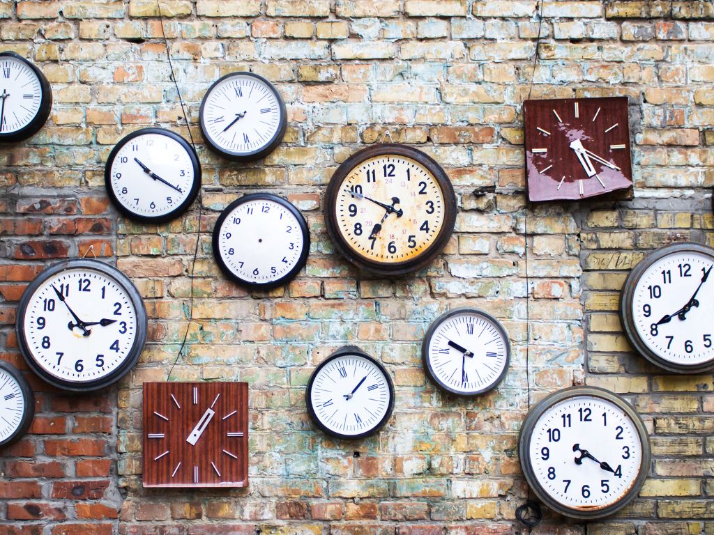 Collection of vintage clock hanging on an old brick wall