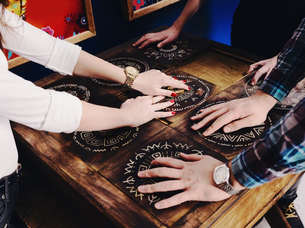 The hands of young people move pieces of the Mexican style trying to get out of the trap, escape the room game concept