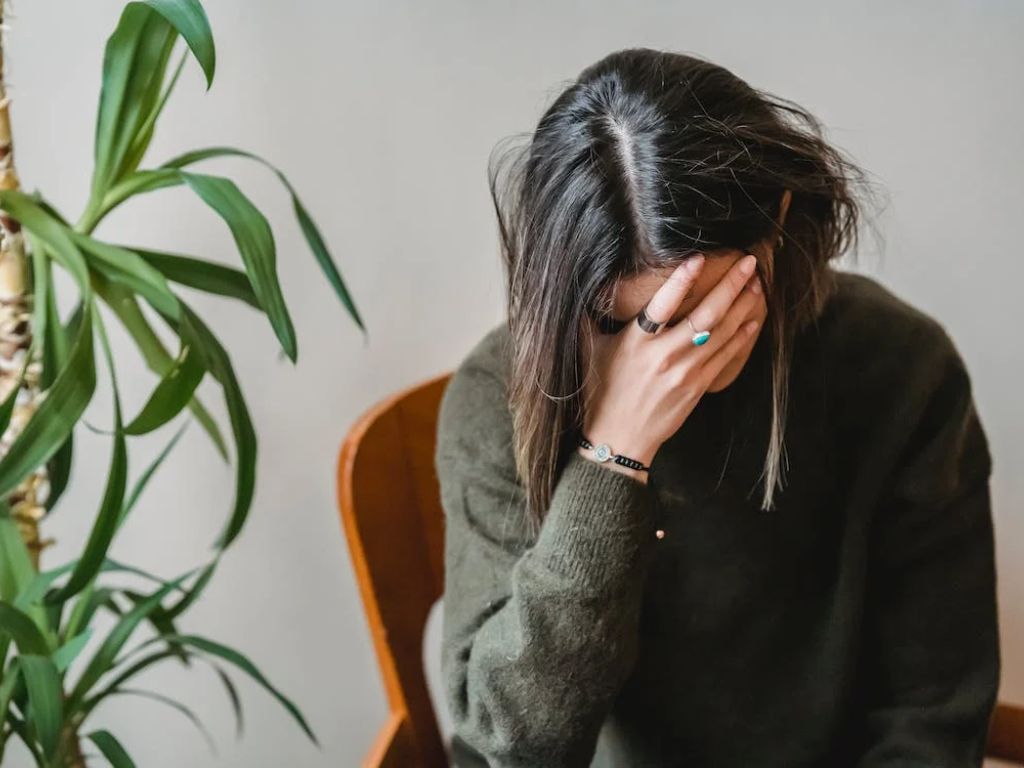 Worried young woman covering face with hand