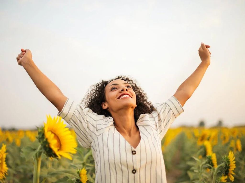 Woman standing on sunflower field