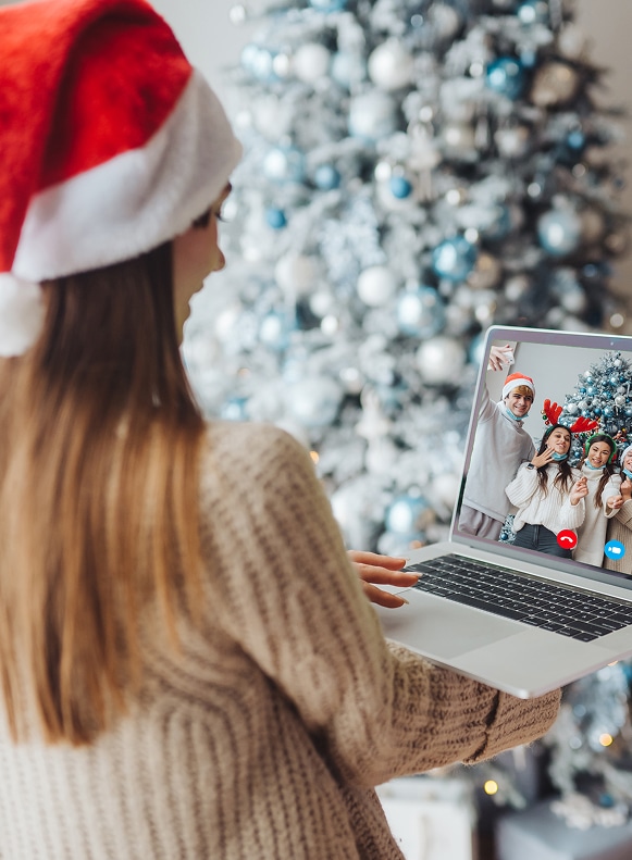 Remote employees smiling while joining a virtual Christmas party with interactive games.
